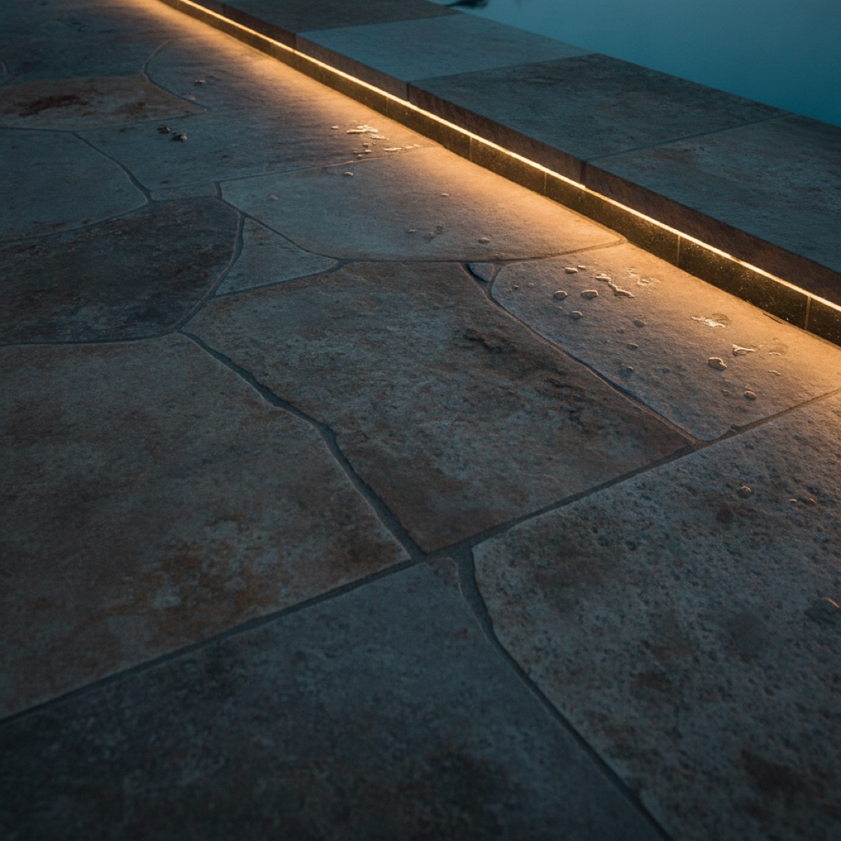 Close-up of expertly finished pool stonework at dusk, tangible proof behind the real numbers